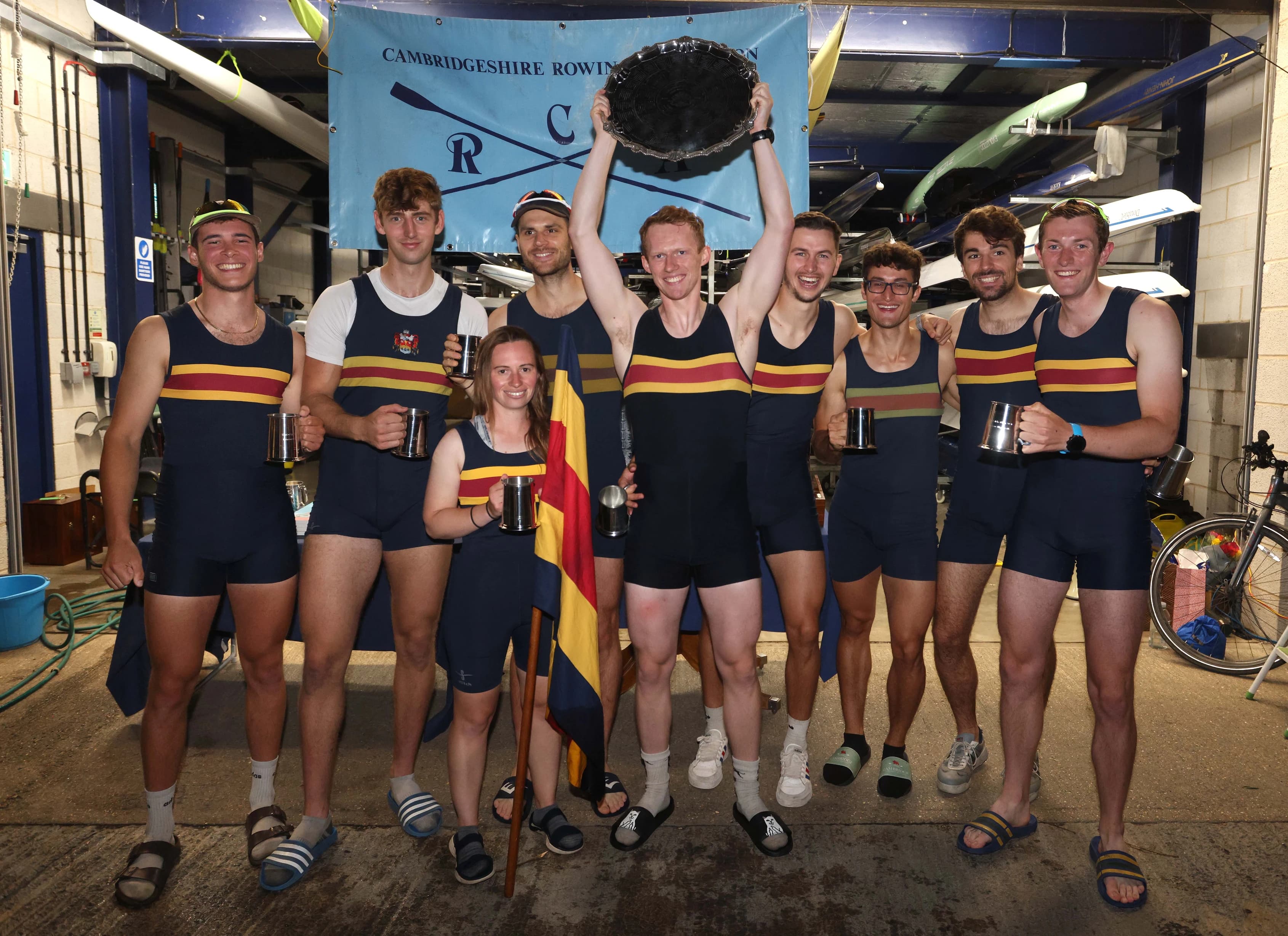 Photo of crew in front of boathouse.